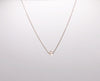 A single crystal hanging from a delicate gold chain necklace.