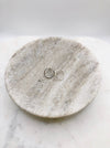 A pair of silver hoop studs lightly textured displayed in a shallow marble bowl. The earrings measure approximately 2cm each in diameter.